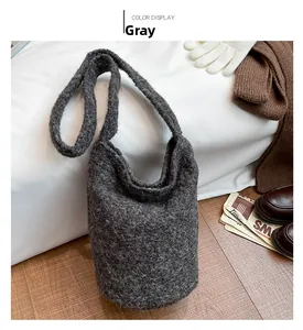 Gros plan du sac seau en tricot gris à texture pelucheuse sur un décor d'automne