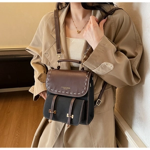Detail of vintage bicolor backpack featuring contrast stitching and metallic buckle accents