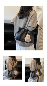 Détail du sac cabas vintage noir avec un pendentif ours en peluche et un design plissé