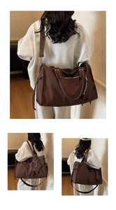 Detail of solid brown large tote bag with adjustable shoulder strap and small pouch charm
