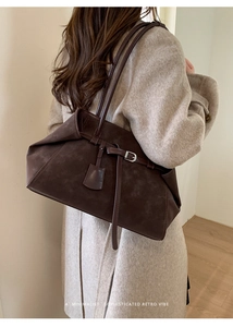Macro view of dark brown suede tote bag featuring a minimalist retro belt buckle detail