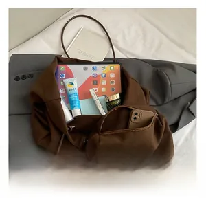 Detail view of large dark brown tote bag showing spacious interior with zipper pocket
