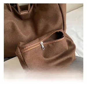 Detail of dark brown felt tote bag showing premium silver zipper and inner pouch texture
