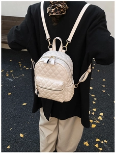 Sac à dos en similicuir matelassé avec bretelles réglables montré dans une scène de rue chic