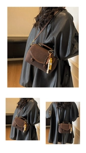 Detail of vintage dark brown suede crossbody bag with beaded charm and embossed logo