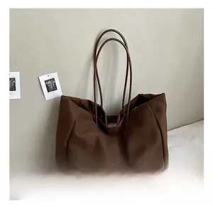 Detail view of the brown large tote bag showing high-quality canvas texture and dual handles