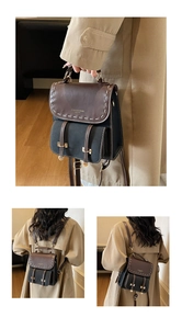 Detail of vintage mini backpack with brown leather flap, contrast stitching and gold buckles