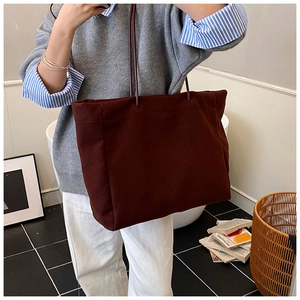 Detail of burgundy tote bag with leather straps and spacious interior for daily use