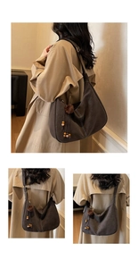 Detail of hobo bag with white contrast stitching and a plush brown pompom charm