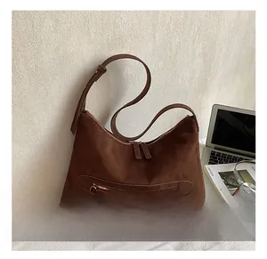 Macro view of dark brown faux suede tote bag detailing the smooth matte texture and zip pockets