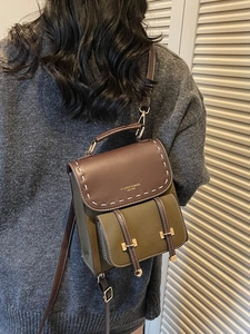 Vintage olive green and brown leather backpack with contrast stitching and metal buckles
