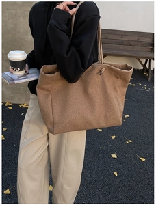 Macro detail of high-capacity dark brown felt tote bag with slim shoulder strap