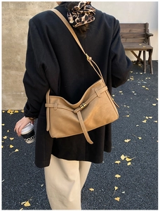 Gros plan d'un sac cabas en cuir marron avec fermoir métallique sur un banc