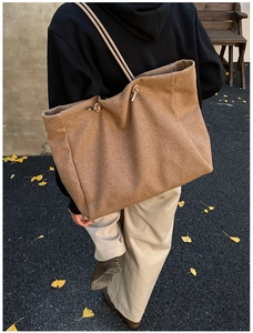 Brown felt tote bag with knotted rope shoulder strap shown on a model in autumn setting