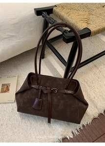 Close-up of vintage dark brown faux suede tote bag with elegant long shoulder straps