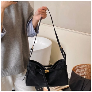 Détail du sac cabas en daim noir avec fermoir rotatif doré et bandoulière élégante