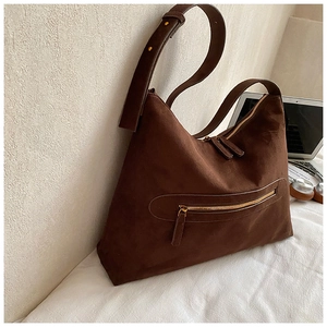 Detail of deep brown suede-texture shoulder bag with gold zipper and spacious interior