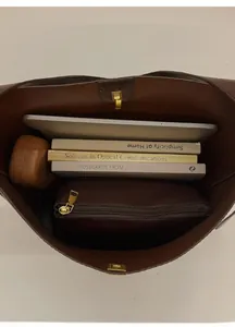 Vue de dessus de l'intérieur spacieux du cabas marron foncé avec livres et accessoires