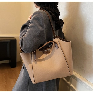 Detail of a large lychee-textured tote bag showing the side view on a model's shoulder