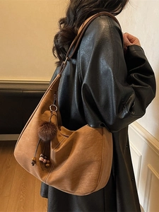 Vintage brown suede hobo bag with contrast stitching and decorative tassel charm