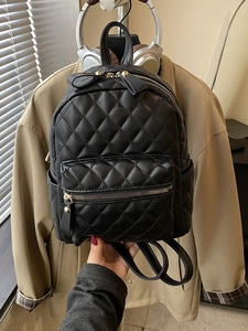 Chic black quilted mini backpack made of PU leather with front zipper pocket and handle