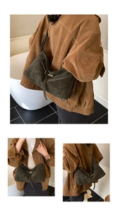 Detail of dark olive green suede tote bag with stylish buckle strap and adjustable shoulder strap