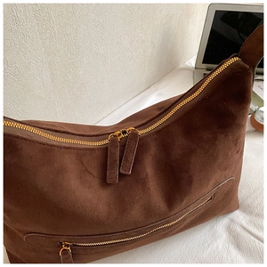 Macro shot of dark coffee suede tote with golden double zippers and premium textured fabric