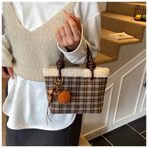 Close-up of winter plaid bucket bag featuring white faux fur trim and cute heart charms
