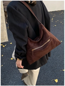 Detail of dark brown suede tote bag with stylish arc zipper pocket for fall and winter