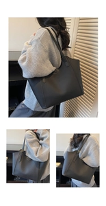 Detail of black tote bag featuring premium pebble leather and embossed fashion logo