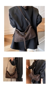 Detail of a large brown matte shoulder bag with golden buckle and sleek leather straps