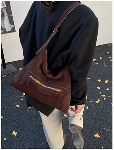 Detail of dark brown suede hobo bag with front zip pocket and stylish wide shoulder strap