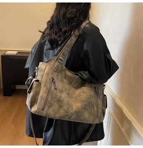 Retro washed leather tote bag shown on model featuring double zippers and wide straps
