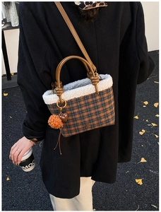 Detail of checkered plush bucket bag with fuzzy white trim and a heart charm