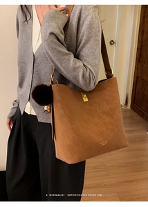 Gros plan du sac seau caramel avec fermoir tournant doré et logo de la marque