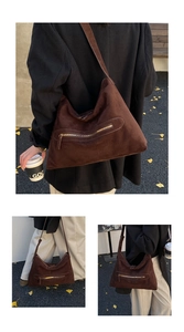 Close-up of large brown faux suede tote bag with metal zipper pocket and wide shoulder strap
