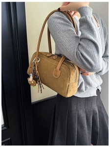 Brown suede Boston bag detail with plush bear charm and leather shoulder strap