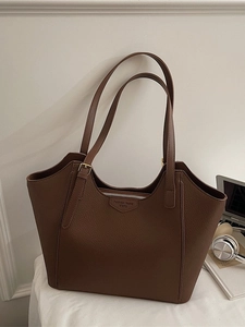 Brown large capacity leather tote bag with dual straps and laptop on white background