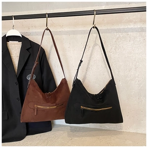 Detail of vintage suede hobo bags in brown and black with decorative metal zippers