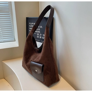 Detail of dark brown matte suede Hobo bag with leather strap and front metal buckle pocket