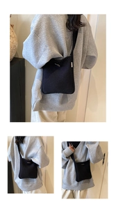 Detail of minimalist black knit crossbody bag with silver buckle and MISS woven label