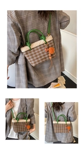 Detail view of plaid plush bucket bag with lamb wool trim and green leather handle