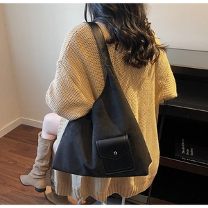 Close-up of black matte suede tote bag featuring a practical front leather pocket and strap