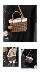Detail of plaid bucket bag featuring faux shearling trim, heart charm, and a brown pompom