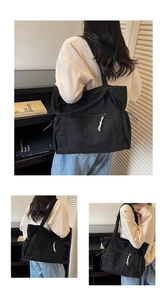 Close-up of black corduroy tote bag featuring vertical texture and side drawstring detail