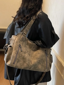 Retro distressed taupe tote bag with dual handles and zipper details on a model