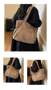 Macro detail of camel corduroy tote bag featuring metal zipper pocket and drawstring