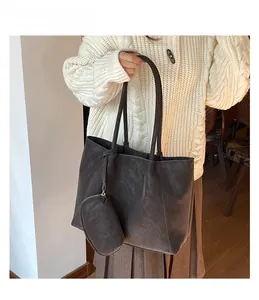 Close-up of dark brown matte tote bag with matching zippered pouch and long shoulder strap