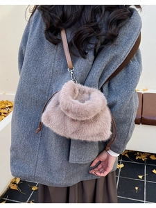 Detail of plush bucket bag with drawstring closure and brown leather shoulder strap