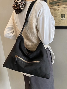 Large black suede tote bag for women with gold zipper detail and adjustable strap